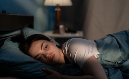 Image: Adobe Sad woman lying on bed